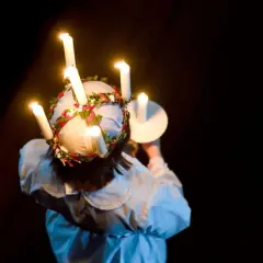 En flicka med ljus i håret, en svensk tradition. Frågan om det är haram att fira jul är komplex och beror på tolkning.