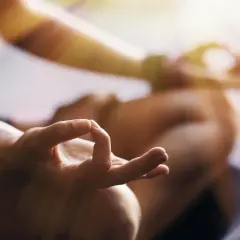 En person med en hand i mudra-position, som en del av en meditation eller bön. En lugn stund för دعاء يوم الثلاثاء.