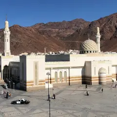 Stor moské med kupol och minareter, bakom berg. Platsen är känd som profeten Muhammeds grav.