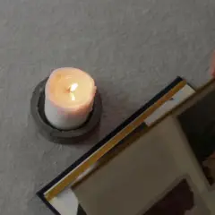 Ett tänt ljus och en fotoalbum. En hand bläddrar i albumet, kanske för att minnas någon. En dua när någon dör.