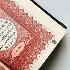 En öppen Koran med vackra röda mönster. Sura Al-Fatiha, den första suran i Koranen, visas.