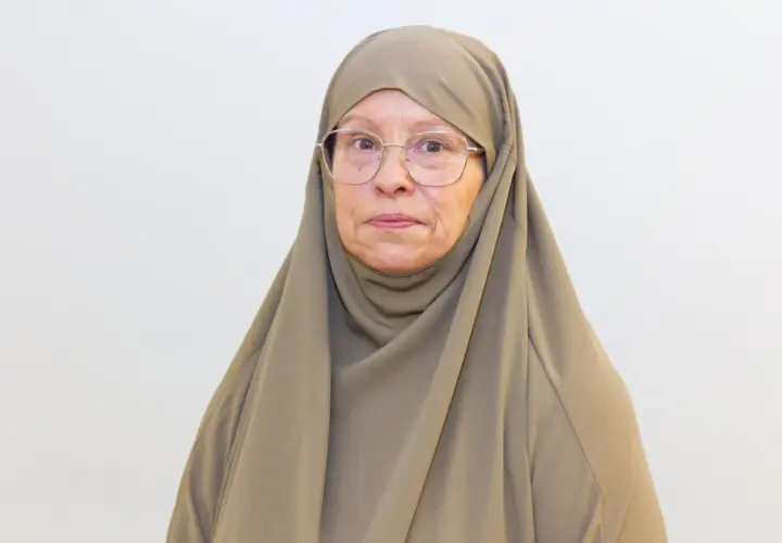 Äldre kvinna med hijab och glasögon, funderar på om det är haram att fira födelsedagar.