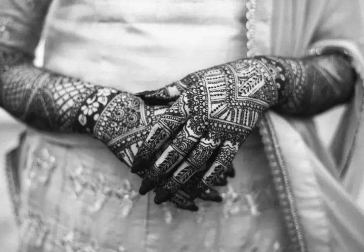 Händer med intrikata mönster av henna. Frågan om "is tattoo haram" kan vara relevant för vissa, men detta är temporär konst.