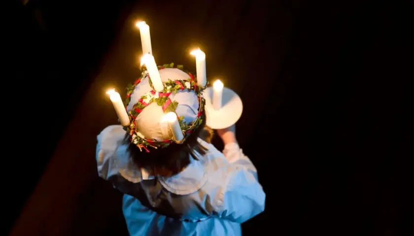 En flicka med ljus i håret, en svensk tradition. Frågan om det är haram att fira jul är komplex och beror på tolkning.