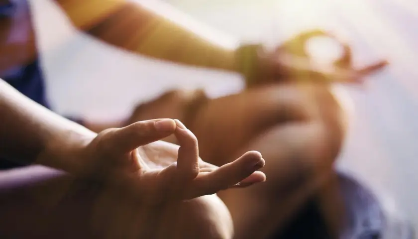 En person med en hand i mudra-position, som en del av en meditation eller bön. En lugn stund för دعاء يوم الثلاثاء.