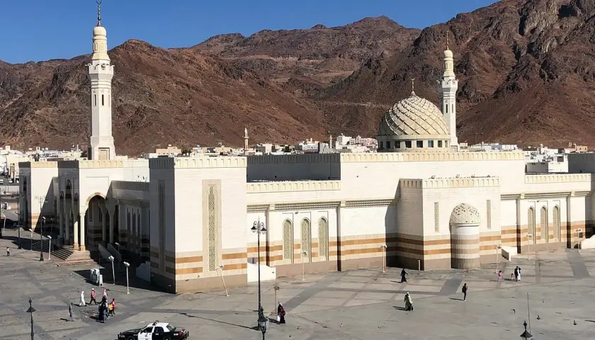 Stor moské med kupol och minareter, bakom berg. Platsen är känd som profeten Muhammeds grav.