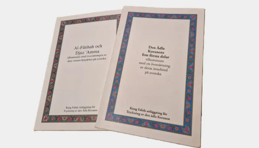 Två böcker med text från Koranen, inklusive surah al Kahf, översatta till svenska.