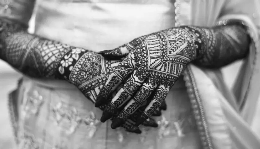 Händer med intrikata mönster av henna. Frågan om "is tattoo haram" kan vara relevant för vissa, men detta är temporär konst.