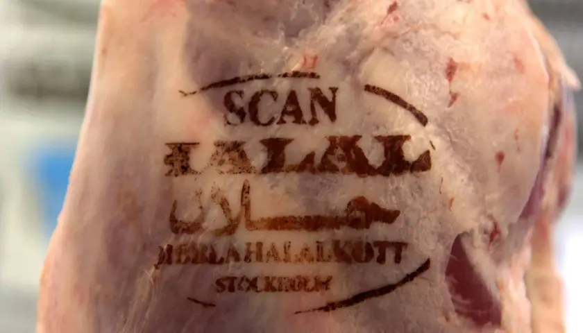 Stämplad text på kött: "SCAN HALAL" och arabisk skrift, vilket förklarar vad betyder halal. Köttet är märkt "MEBLAHALALKÖTT STOCKHOLM".