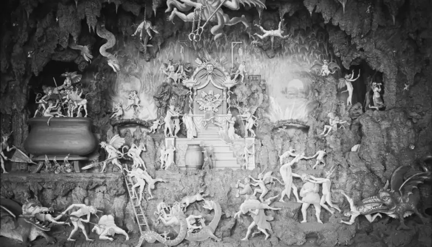 En detaljerad diorama visar scener av helvetet i islam, med demoner som plågar själar i en grottliknande miljö.