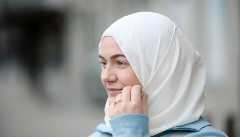 En ung kvinna med blå ögon och vit hijab, funderar på hur man blir muslim.