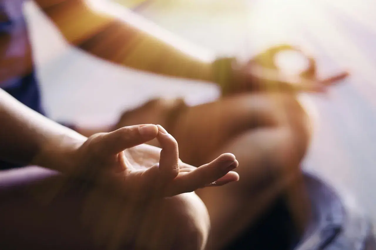 En person med en hand i mudra-position, som en del av en meditation eller bön. En lugn stund för دعاء يوم الثلاثاء.