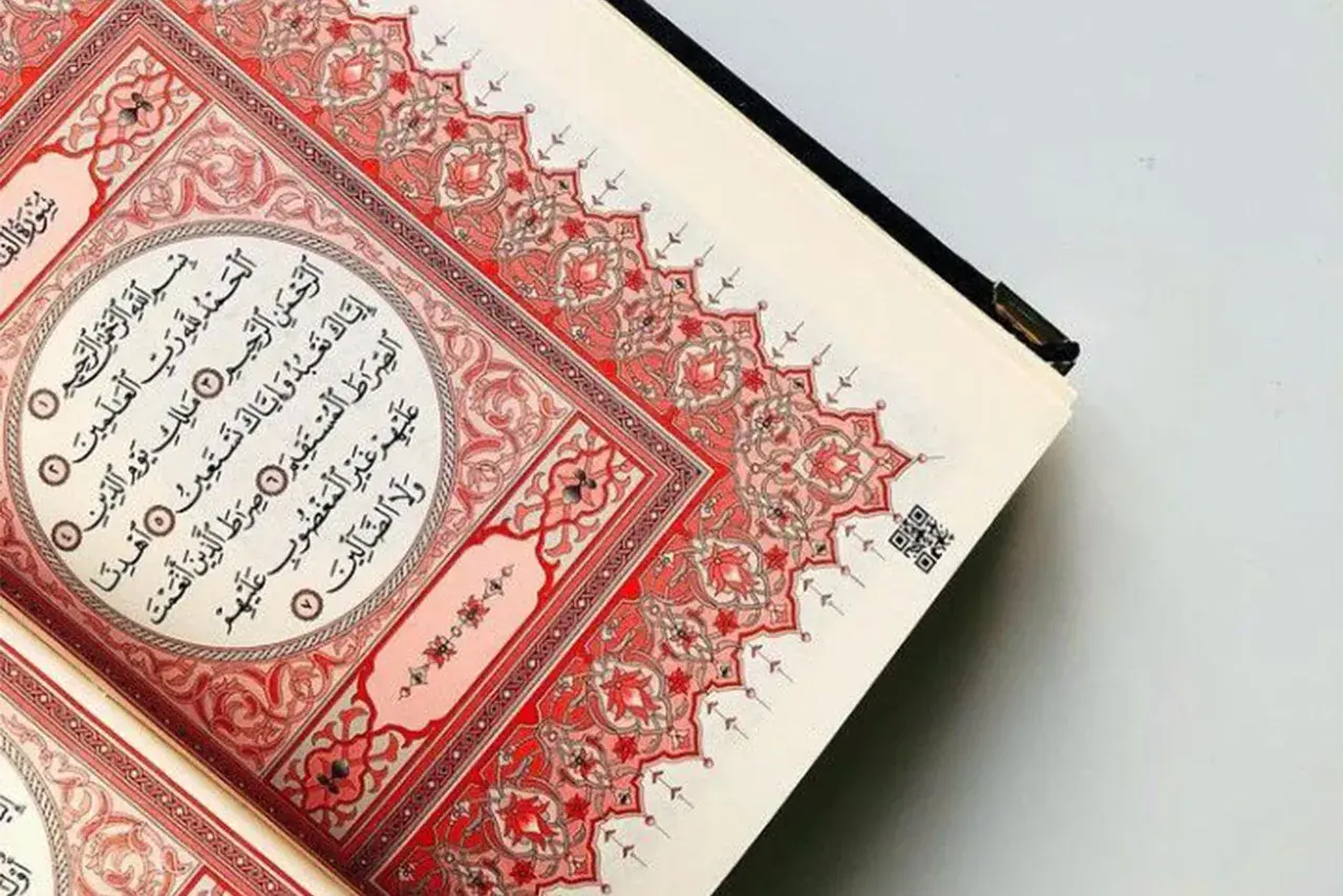 En öppen Koran med vackra röda mönster. Sura Al-Fatiha, den första suran i Koranen, visas.