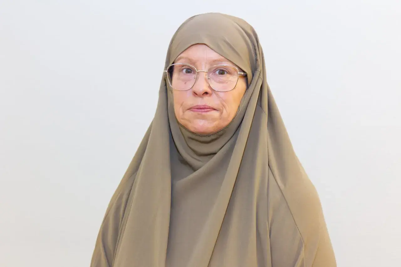 Äldre kvinna med hijab och glasögon, funderar på om det är haram att fira födelsedagar.