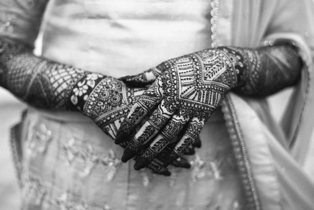 Händer med intrikata mönster av henna. Frågan om "is tattoo haram" kan vara relevant för vissa, men detta är temporär konst.