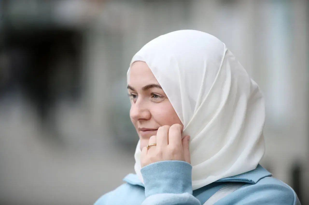 En ung kvinna med blå ögon och vit hijab, funderar på hur man blir muslim.