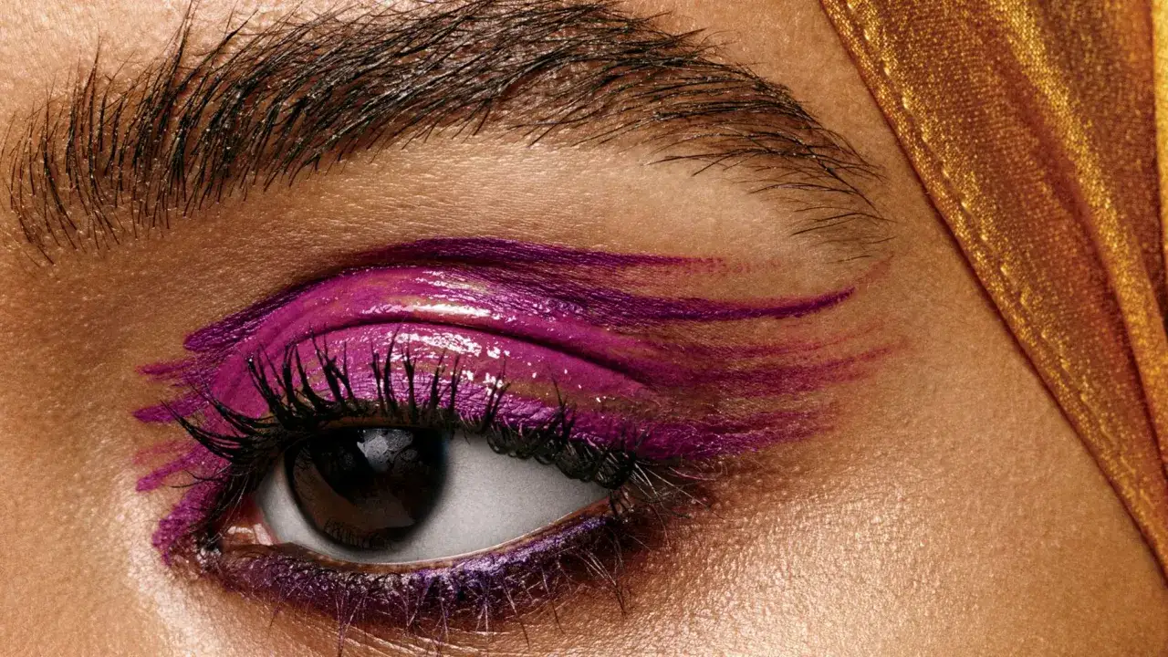Ett öga med dramatisk lila makeup. Frågan om makeup är haram kan vara komplex, men här är ett konstnärligt uttryck.