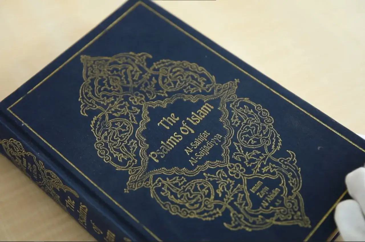 Mörkblå bok med guldig text: