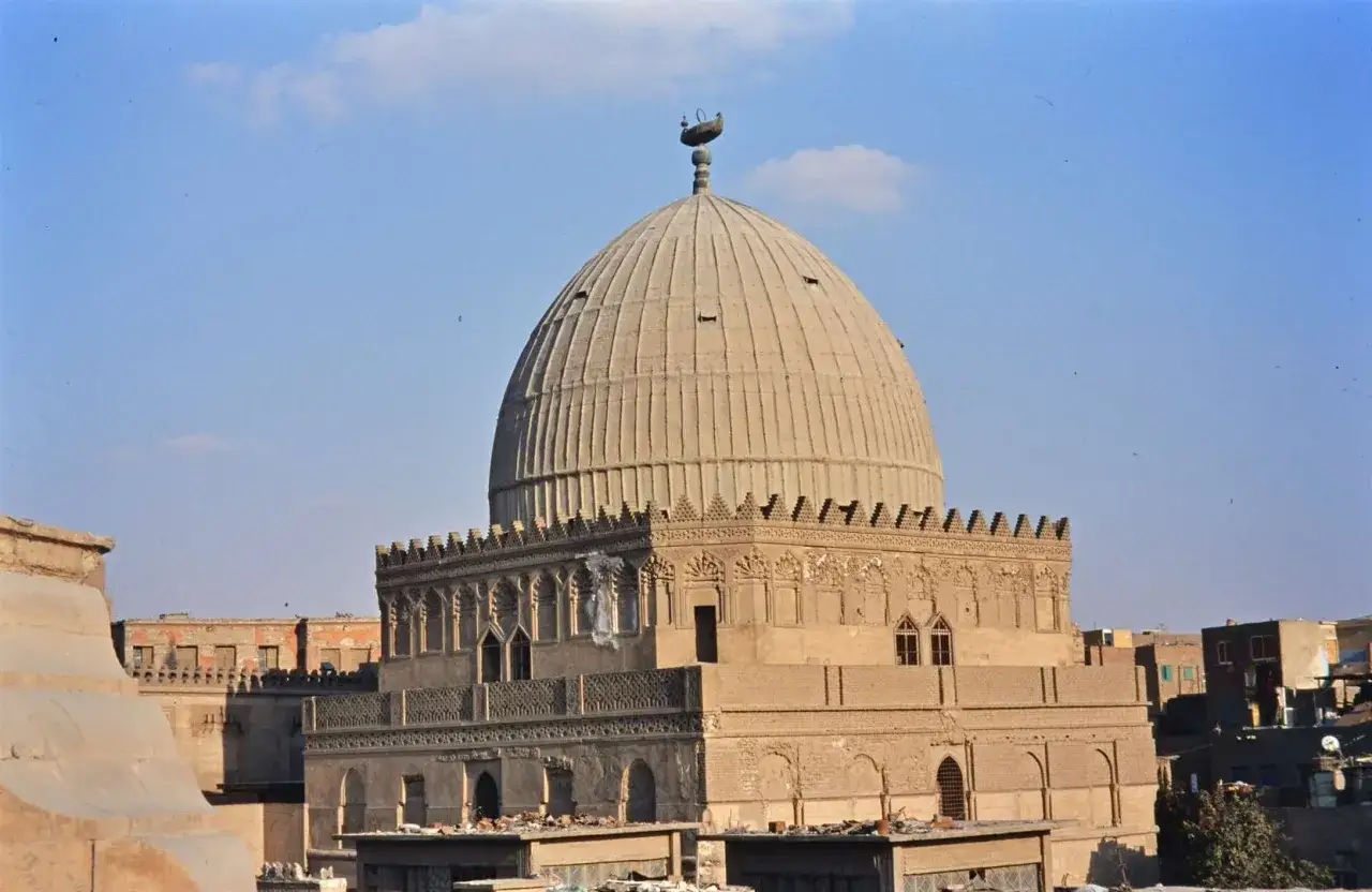 Imam Shafi-mausoleetets kupol med detaljerad fasad och omgivande byggnader under en klarblå himmel.
